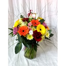  Букет от рози, гербер, спрей рози и хризантема, поднесен във изящна ваза. 