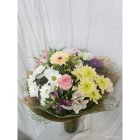 Пъстроцветен букет от рози, алстромерия, орхидея , хризантема и гербер, обгърнат с мрежа и крафт хартия.