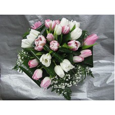 Нежен букет с бели и розови лалета аранжиран с нежна зеленина, гипсофил, листа аспедистра и берграс