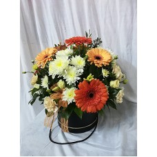 Кутия с гербери, хризантема и еустома в топли жълто оранжеви тонове.