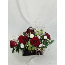 Пет червени рози аранжирани в стилна черна чантичка.