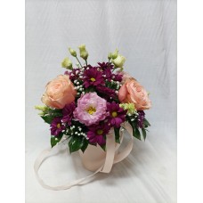 Рози цвят праскова в комбинация с еустома и хризантема, аранжирани в кутия.