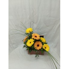 Жълти и оранжеви гербери, аранжирани в стилна кутия.