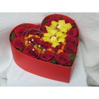 Кутия сърце аранжирана с прекрасни червени рози в комбинация с орхидея цимбидиум.