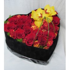 Кутия сърце аранжирана с червени рози и жълт цимбидиум.