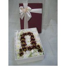 Буква от хризантемки ,арнжирана в кутия.