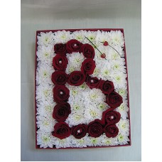 Буква от рози аранжирана в кутия.